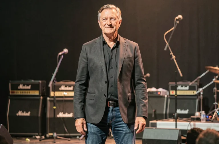 Chanteur français grand de taille debout sur scène, vue en pied illustrant la stature imposante de Florent Pagny